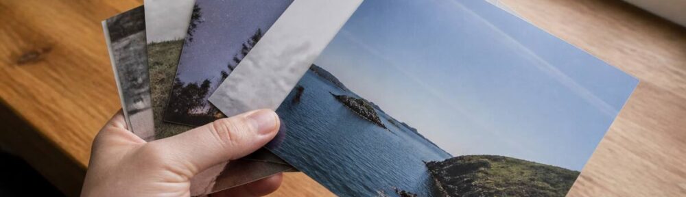 Een realistische foto van afgedrukte foto’s op een houten tafel bij daglicht