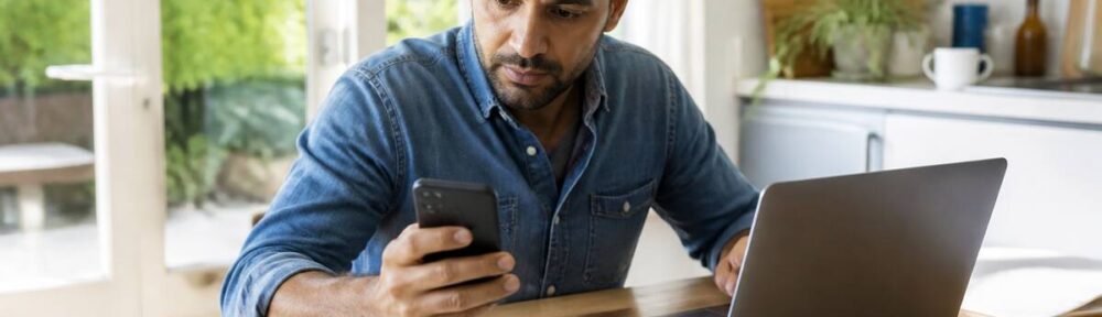 Vakanties vergelijken aan tafel met laptop en telefoon