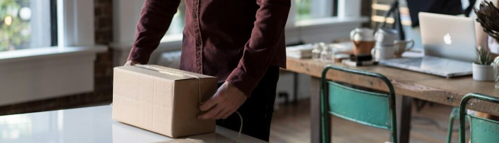 person holding cardboard box on table